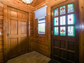 A hallway with a wooden door and glass door at Lodge 4 - Bron Eifion Criccieth