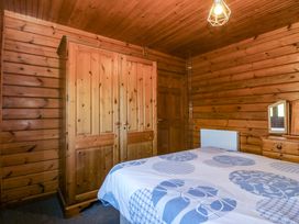 A bedroom with a bed and wardrobe at Lodge 6 - Sleep 4 - Twin and Double in Criccieth