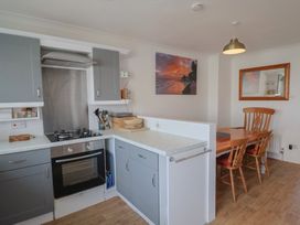 A kitchen with a stove and dining area at 2 Lyme Mews in Seaton