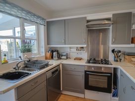 A kitchen with a stove and sink at 2 Lyme Mews Seaton