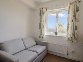 A snug room with a sofa and window at 2 Lyme Mews Seaton