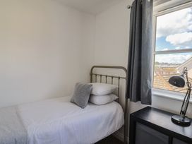 A bedroom with a single bed and lamp at 2 Lyme Mews in Seaton