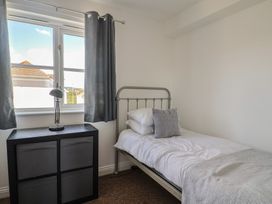 A bedroom with a bed and storage unit at 2 Lyme Mews in Seaton