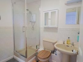 A bathroom with shower, toilet, and sink at 2 Lyme Mews in Seaton