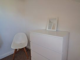 A bedroom with a dresser and a chair at 2 Lyme Mews in Seaton