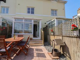 A garden with a patio table and chairs at 2 Lyme Mews in Seaton