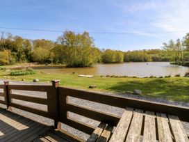 A view of a lake surrounded by trees and grass at Lodge 9 - Sleep 4 - Double and Twin in Criccieth