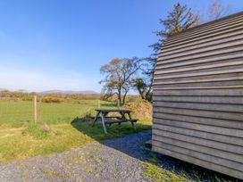 A view of a bench and grass with mountains in the background at Bron Eifion Pod 2 Criccieth