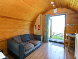 A living room with a sofa and a table at Bron Eifion Pod 3 Criccieth