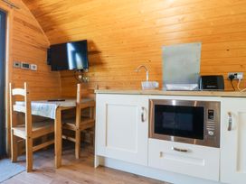 A kitchen with a table and chairs at Bron Eifion Pod 3 in Criccieth