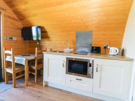 A kitchen with a table and chairs at Bron Eifion Pod 3 Criccieth