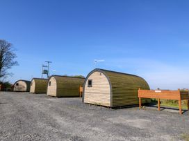 An outdoor area with cabins and a sign at Bron Eifion Pod 3 Criccieth