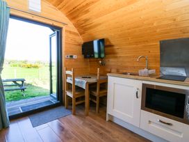 A kitchen with a table and chairs at Bron Eifion Pod 5 in Criccieth