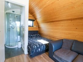 A bedroom with bed and shower at Bron Eifion Pod 5 in Criccieth