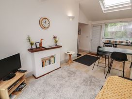 A living room with a television and a dining area at Juniper Hayloft in Ambleside