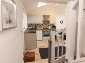 A kitchen with appliances and seating at Juniper Hayloft in Ambleside