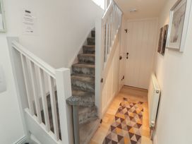 A hallway with stairs leading up and a door at Juniper Hayloft in Ambleside