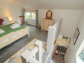 A bedroom with a bed and dresser at Juniper Hayloft in Ambleside