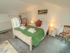 A bedroom with a bed, towels, lamp, chair at Juniper Hayloft in Ambleside