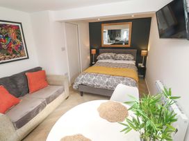 A bedroom with a bed, sofa and table at The Annex in Penzance