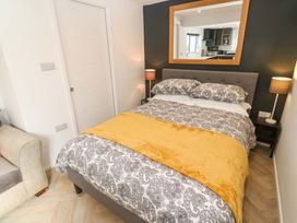 A bedroom with a bed and a chair at The Annex in Penzance