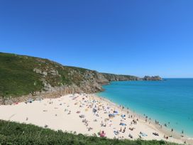 A beach with people and umbrellas at The Annex in Penzance