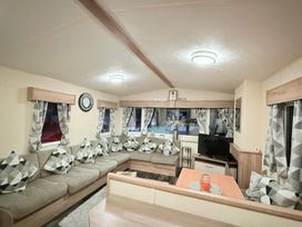 A living room with a sofa, television, and coffee table at Skipsea sands holiday park in Driffield