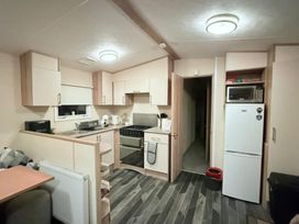 A kitchen with stove, refrigerator, and microwave at Skipsea sands holiday park in Driffield