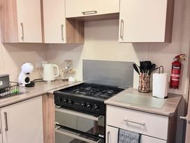 A kitchen with cabinets and a gas stove at Skipsea sands holiday park Driffield