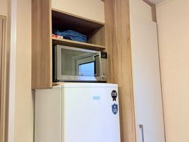 A kitchen with a microwave and refrigerator at Skipsea sands holiday park Driffield