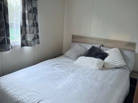 A bedroom with a bed and pillows at Skipsea sands holiday park in Driffield