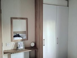 A bedroom with a mirror and wardrobe at Skipsea sands holiday park in Driffield