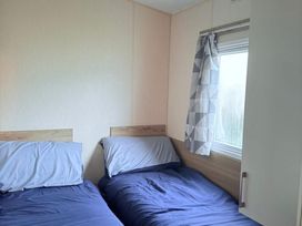 A bedroom with two beds and a window at Skipsea sands holiday park in Driffield