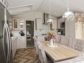 A kitchen with a dining area featuring a table and chairs at Swan Haven in Grange-Over-Sands