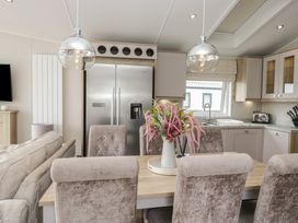 A kitchen with a dining area and a refrigerator at Swan Haven in Grange-Over-Sands