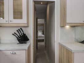 A kitchen with cabinets and a knife block at Swan Haven in Grange-Over-Sands