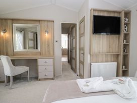 A bedroom with a desk and mirror at Swan Haven in Grange-Over-Sands