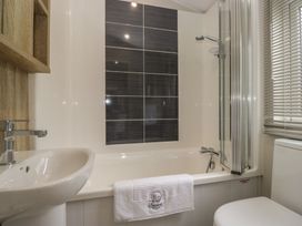 A bathroom with a bathtub, sink and shower at Swan Haven in Grange-Over-Sands