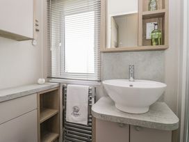 A bathroom with a sink and towel radiator at Swan Haven in Grange-Over-Sands