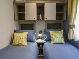 A bedroom with two beds and decorative items at Santa Maria in Llandysul