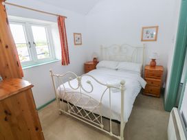 A bedroom with a bed and nightstands at Starling Cottage Cowbridge