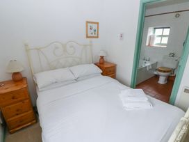 A bedroom with a bed and an adjoining bathroom at Starling Cottage in Cowbridge