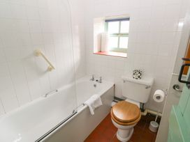 A bathroom with a bathtub and toilet at Starling Cottage in Cowbridge