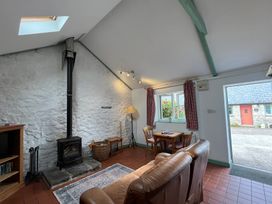 A living room with a fireplace and dining table at Starling Cottage near Cowbridge
