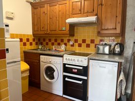 A kitchen with appliances including a fridge, oven, and washing machine at Starling Cottage near Cowbridge