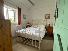 A bedroom with a bed and nightstand at Starling Cottage near Cowbridge