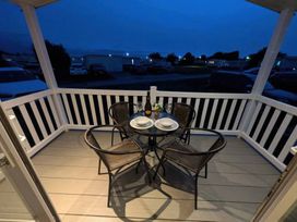 A patio with a table and chairs at 025 Maes Glas in Prestatyn