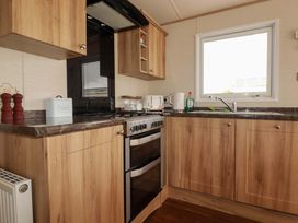 A kitchen with cabinets, stove, sink, and utensils at CC2 