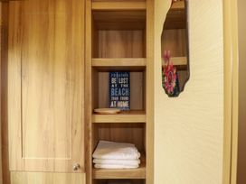 A wooden cabinet with shelves and towels in a bathroom at CC2