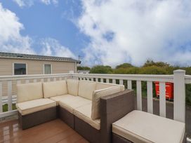 An outdoor area with a sofa and railing at CC2